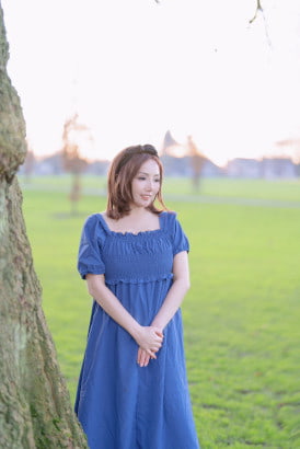 Fair skin South Korean girl in a blue dress standing in a park